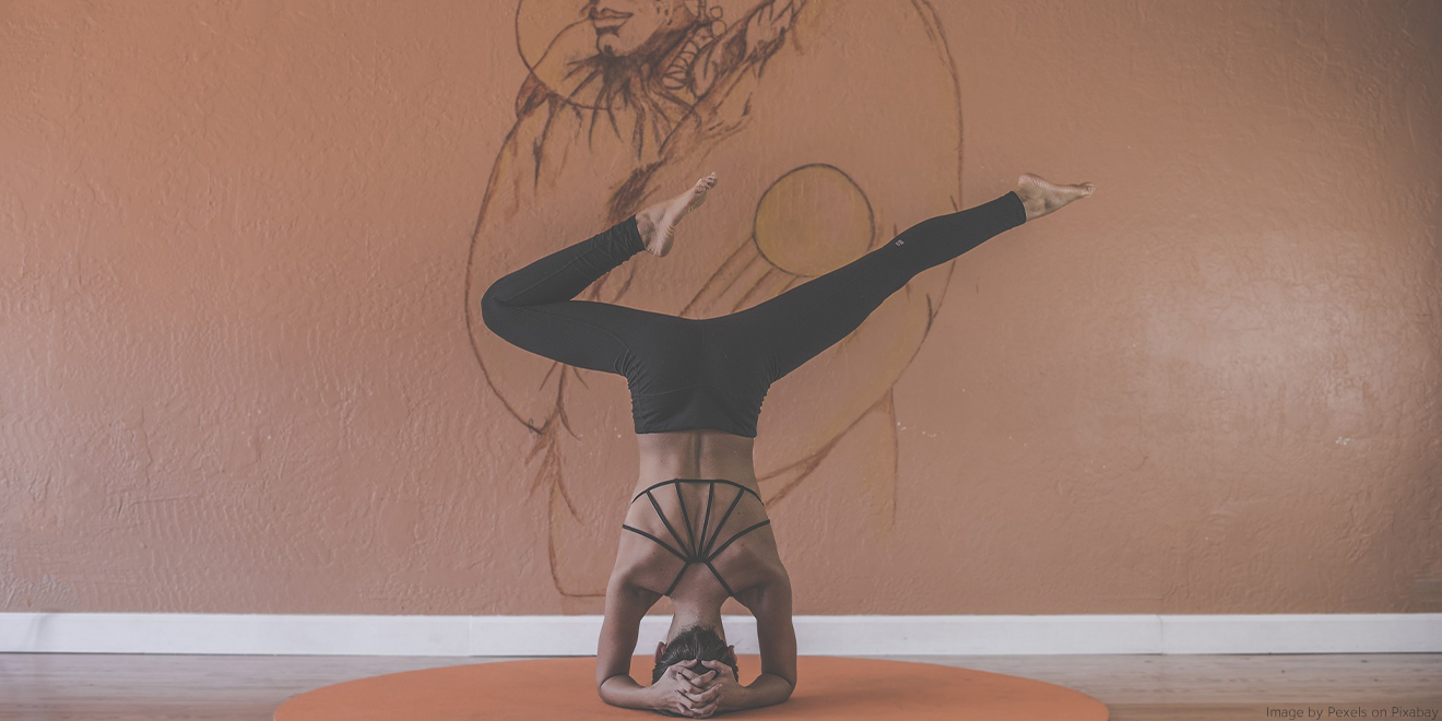 Frau macht akrobatische Yogastellungen um innere Balance für Körper und Geist zu schöpfen