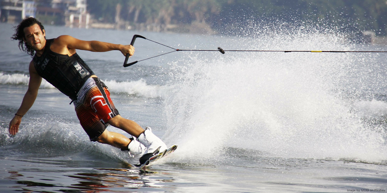 Mann auf einem Wakeboard fährt Wasserski 