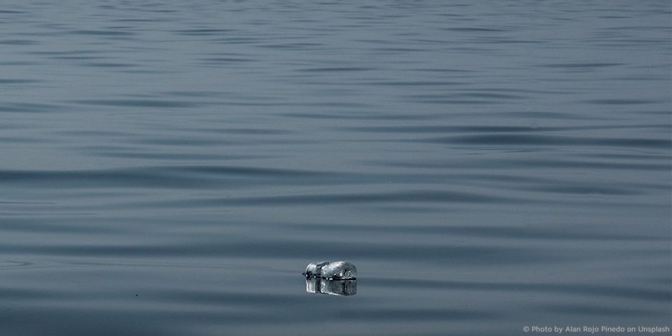 Eine Plastikflasche treibt im Meer