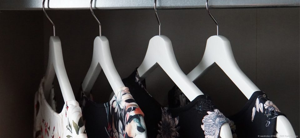 Vier Kleider in einem Kleiderschrank.
