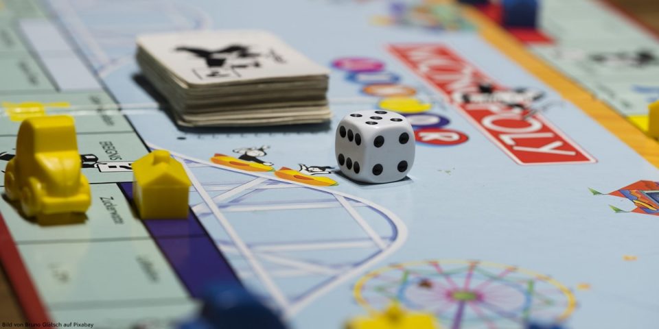 Würfel und Spielfiguren liegen auf einem Gesellschaftsspiel 