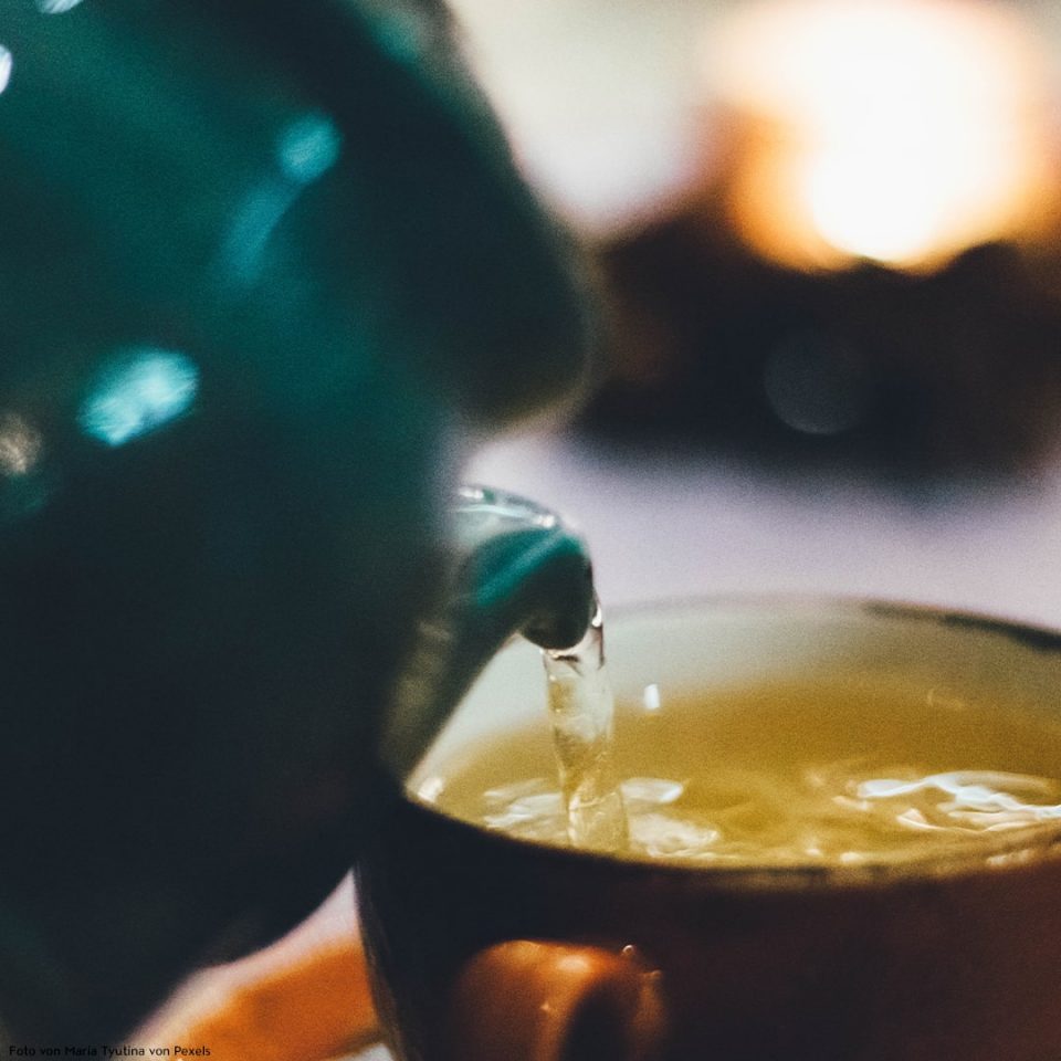 Tee wird in Tasse eingeschenkt