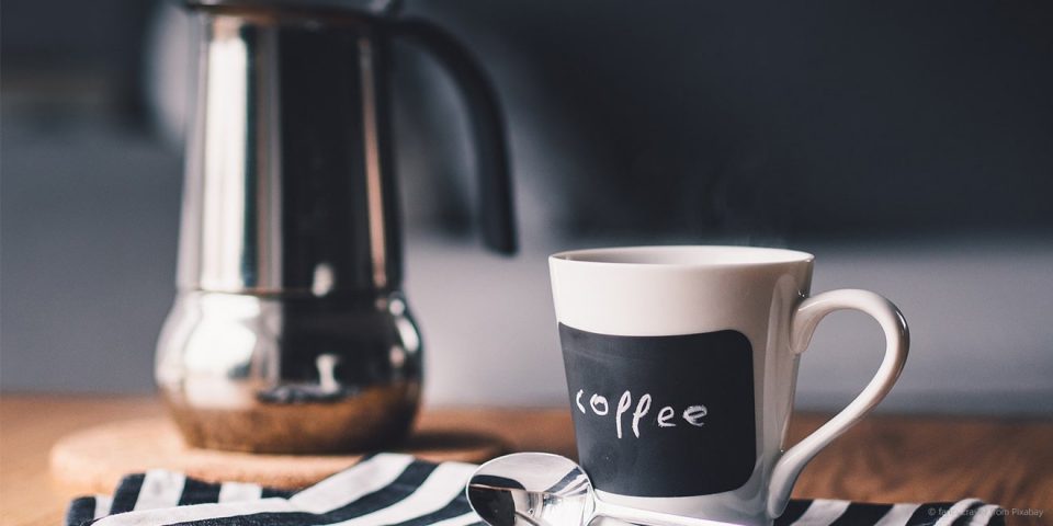 Kanne und Tasse Kaffee auf dem Tisch für eine Pause
