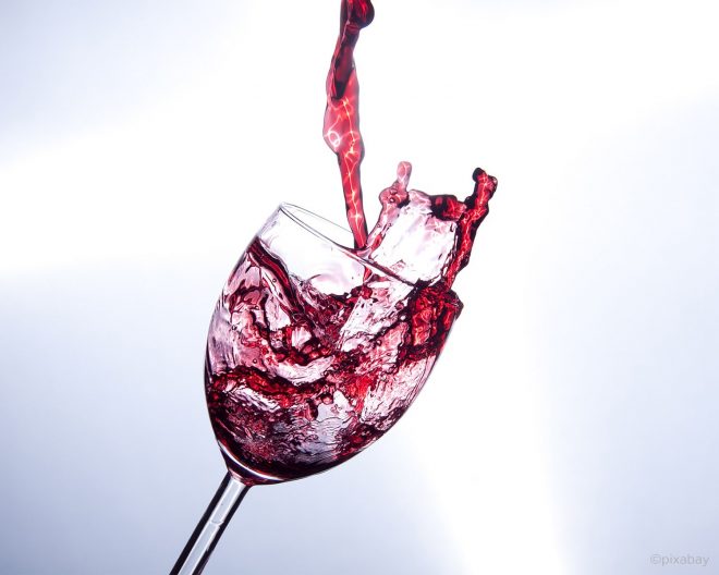 Glas mit Wein kurz vor dem umfallen
