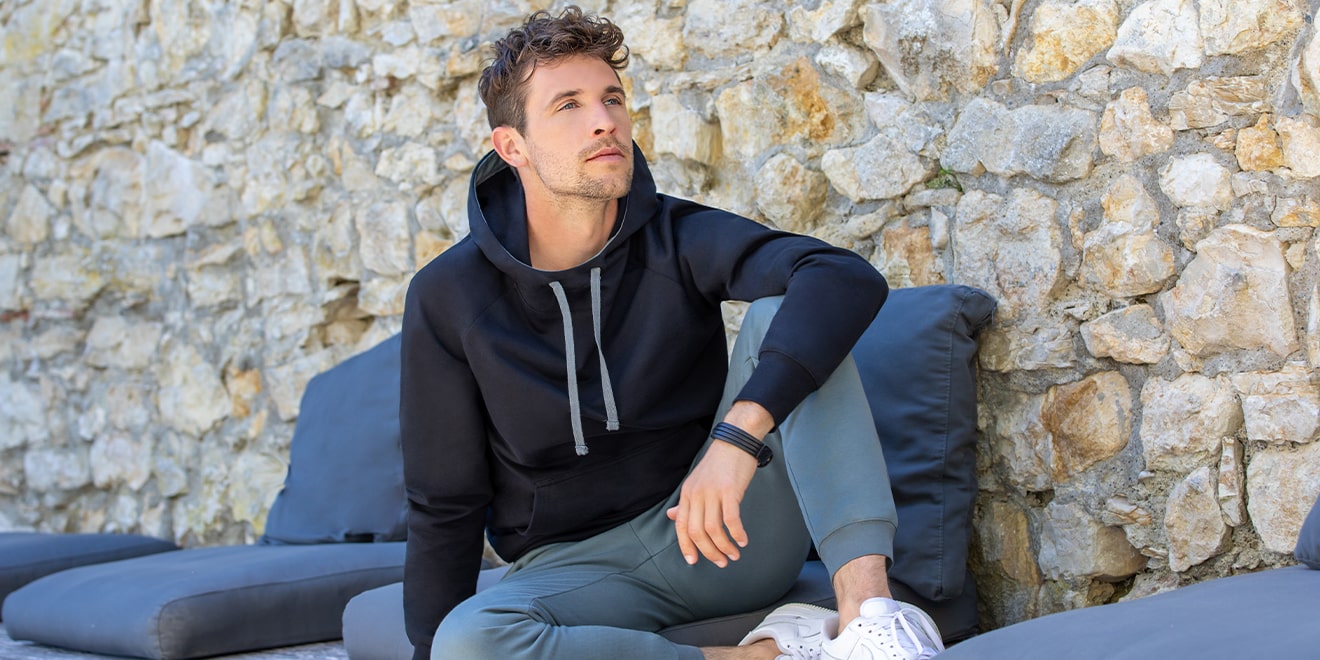 Herr mit Hoodie, der vom Pullover abstammt. Er besteht aus Sweatshirt und Kapuze. 