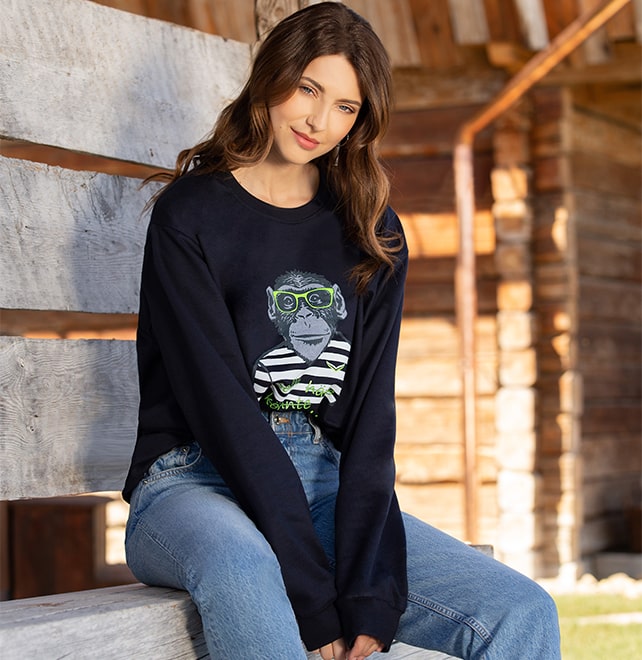Einfach Oversize-Look stylen mit zwei Größen größer: Dame mit dunkelblauem Oversize-Sweatshirt mit Affen-Motiv