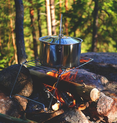 Kochen beim Zelten mit Feuer und Topf