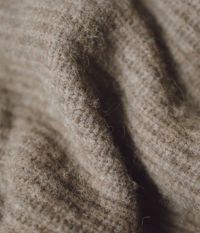 Lange und kurze Paspeln, auch Fasern genannt, in einem Wollpullover.