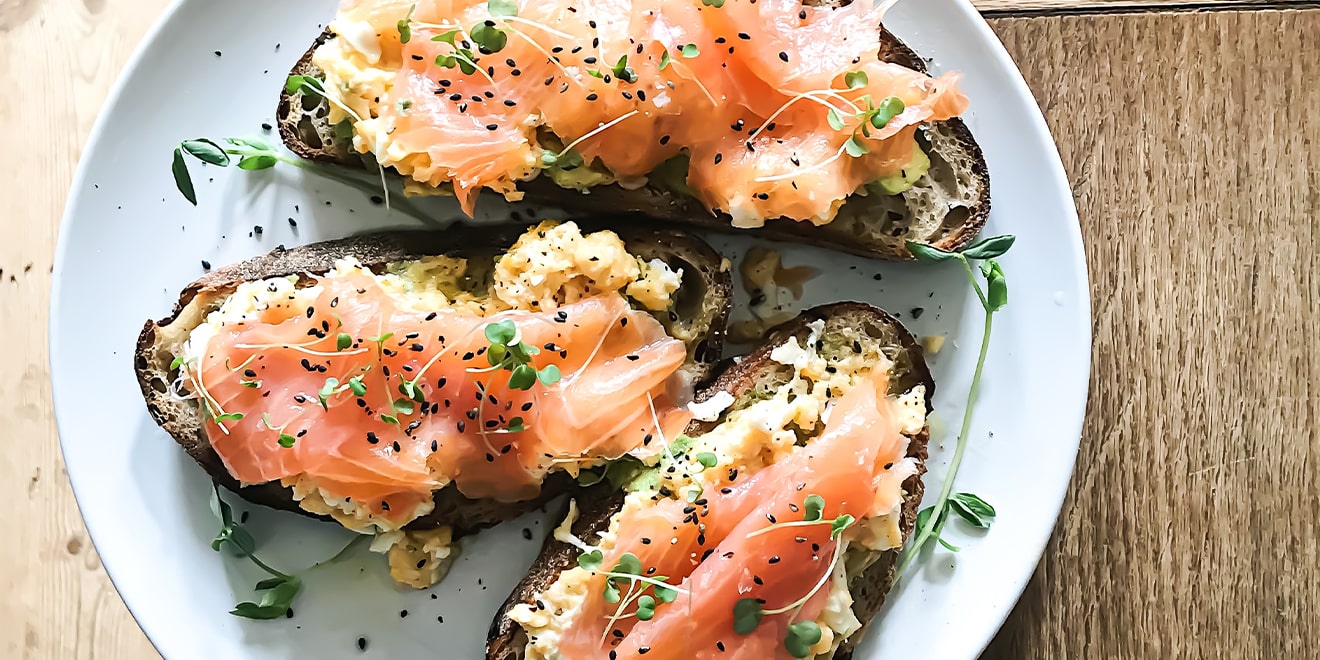Brote belegt mit proteinreichem Lachs und Avocado mit gesunden Fetten. 