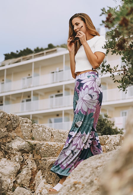 High Waist Hosen strecken die Beine. Ein kurzes Crop Top und eine Sonnenbrille lenken die Aufmerksamkeit auf den Oberkörper um größer zu wirken. 