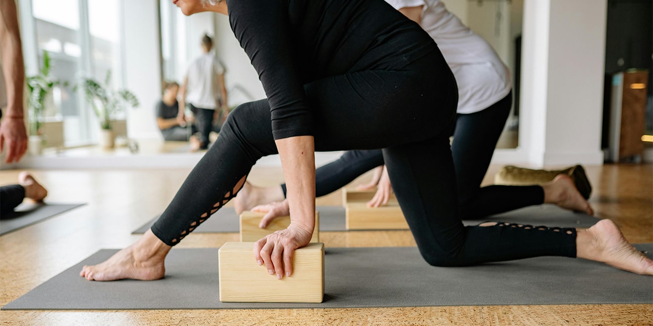 Yogablocks, Stühle, Kissen oder Decken können bei dem Ausführen von Übungen helfen.