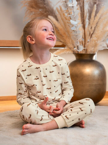 Kind im Dackel Pyjama mit Allovermuster in Natur